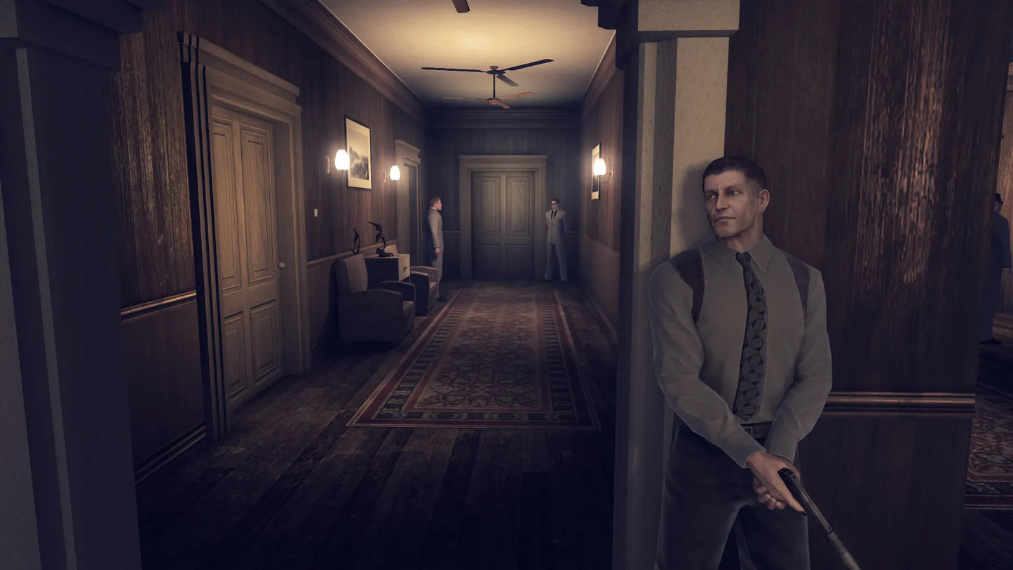 Man in a suit standing in a dimly lit hallway with wooden paneling and a patterned rug.