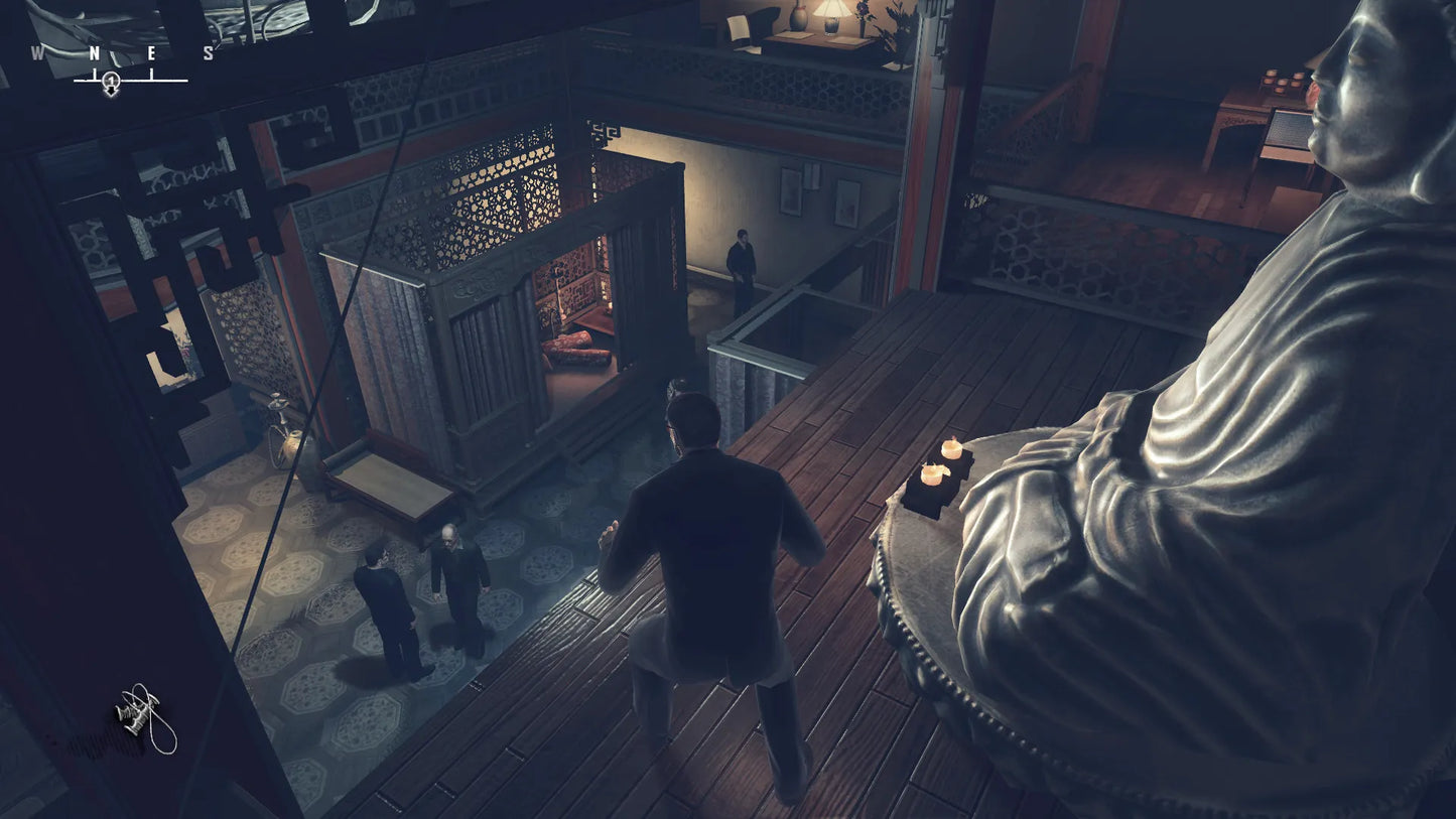 Darkly lit room with a statue and a person walking towards a door.