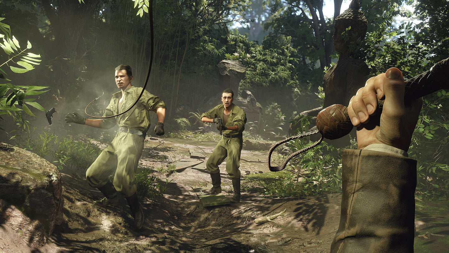 Two soldiers in a jungle setting with a third person holding a weapon.