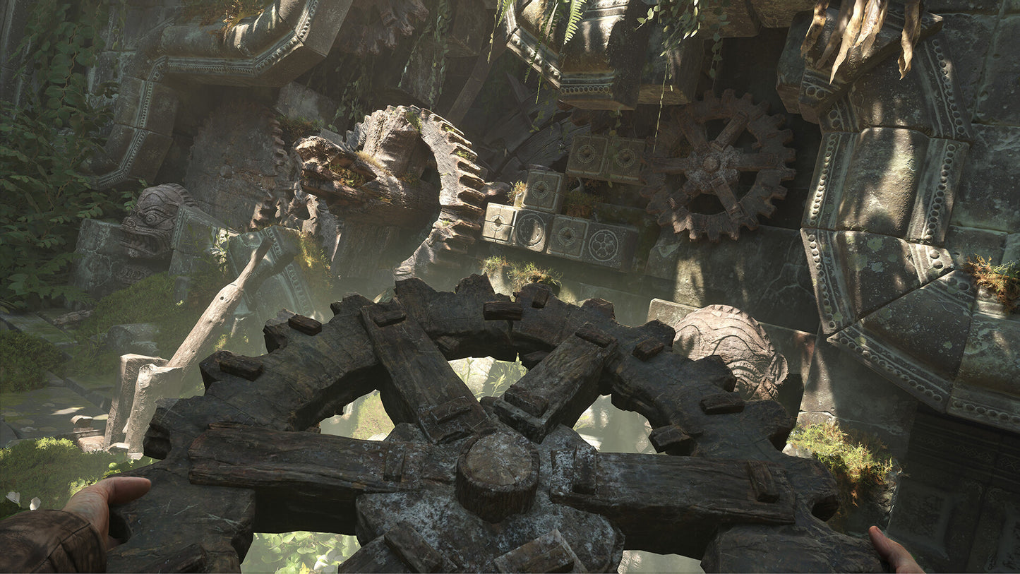 Close-up of large stone gears in a natural setting with greenery.