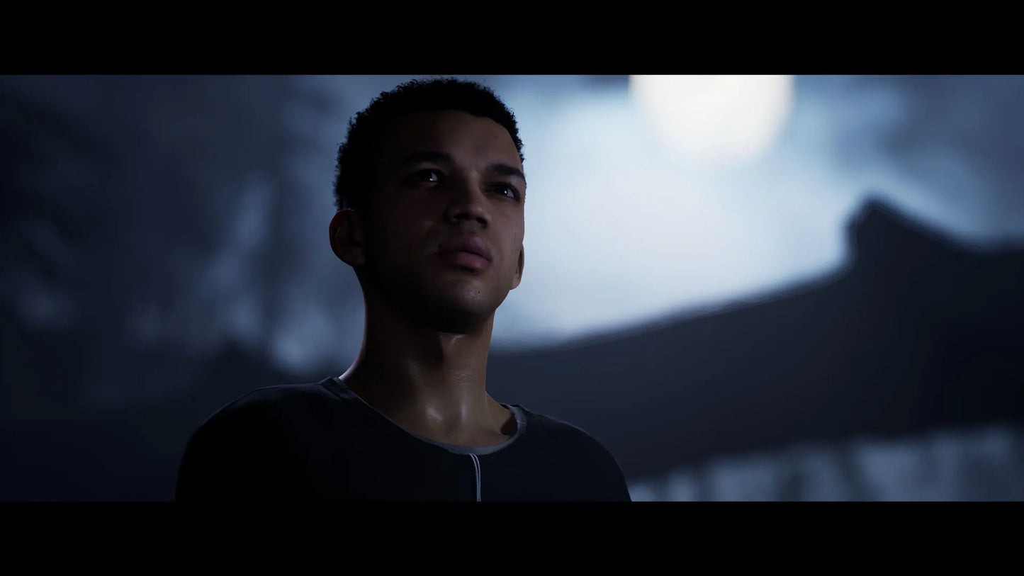 Man standing in a dark setting with a blurred background