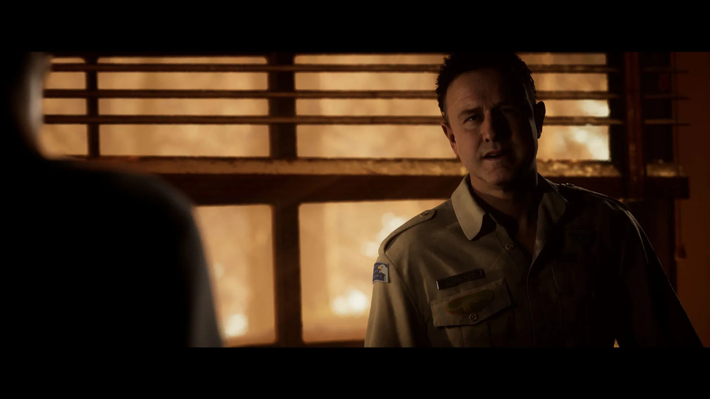 Man in a uniform standing in a dimly lit room with wooden paneling.