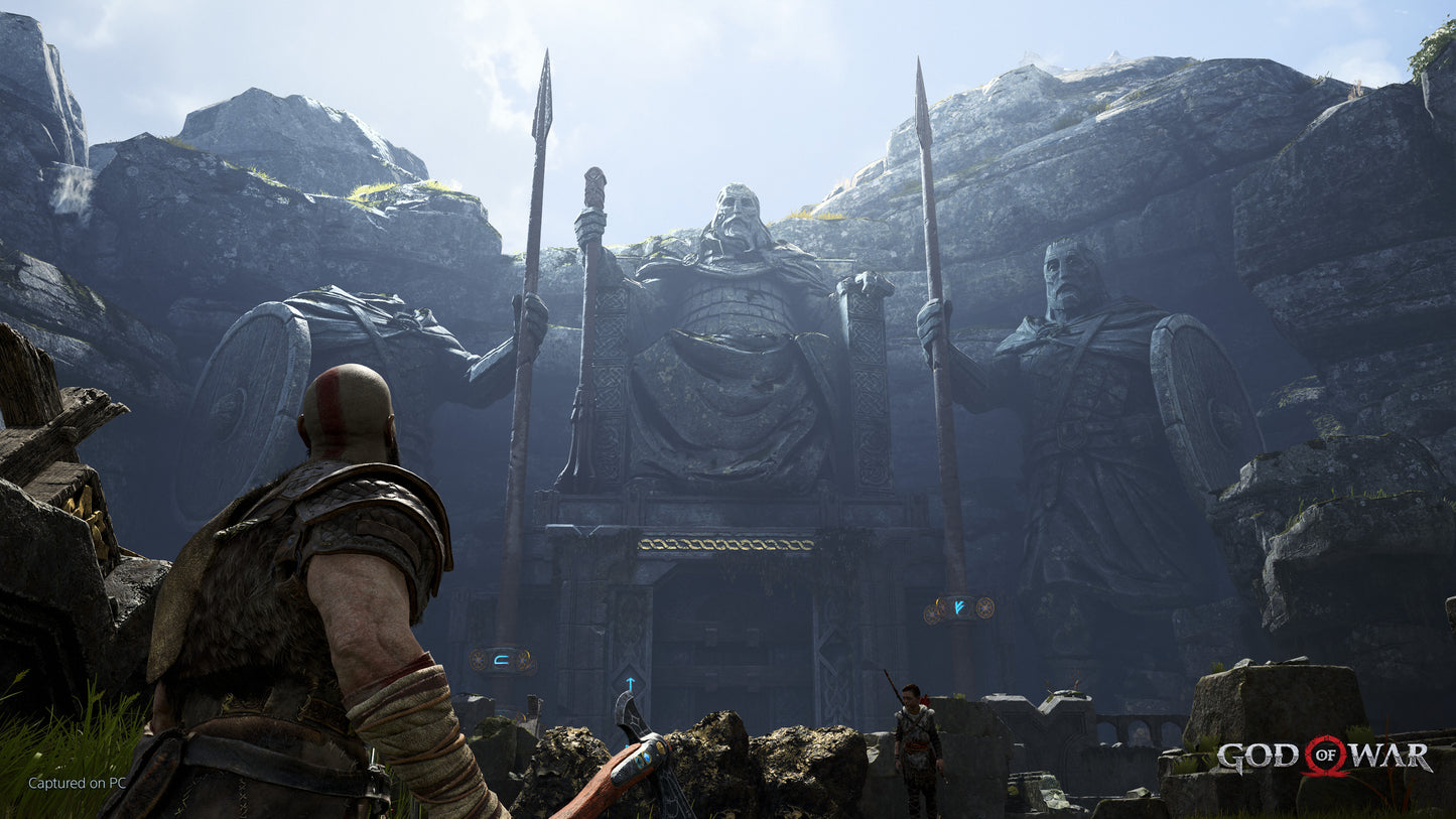 Character facing large statues in a rocky, mountainous landscape with 'God of War' branding.
