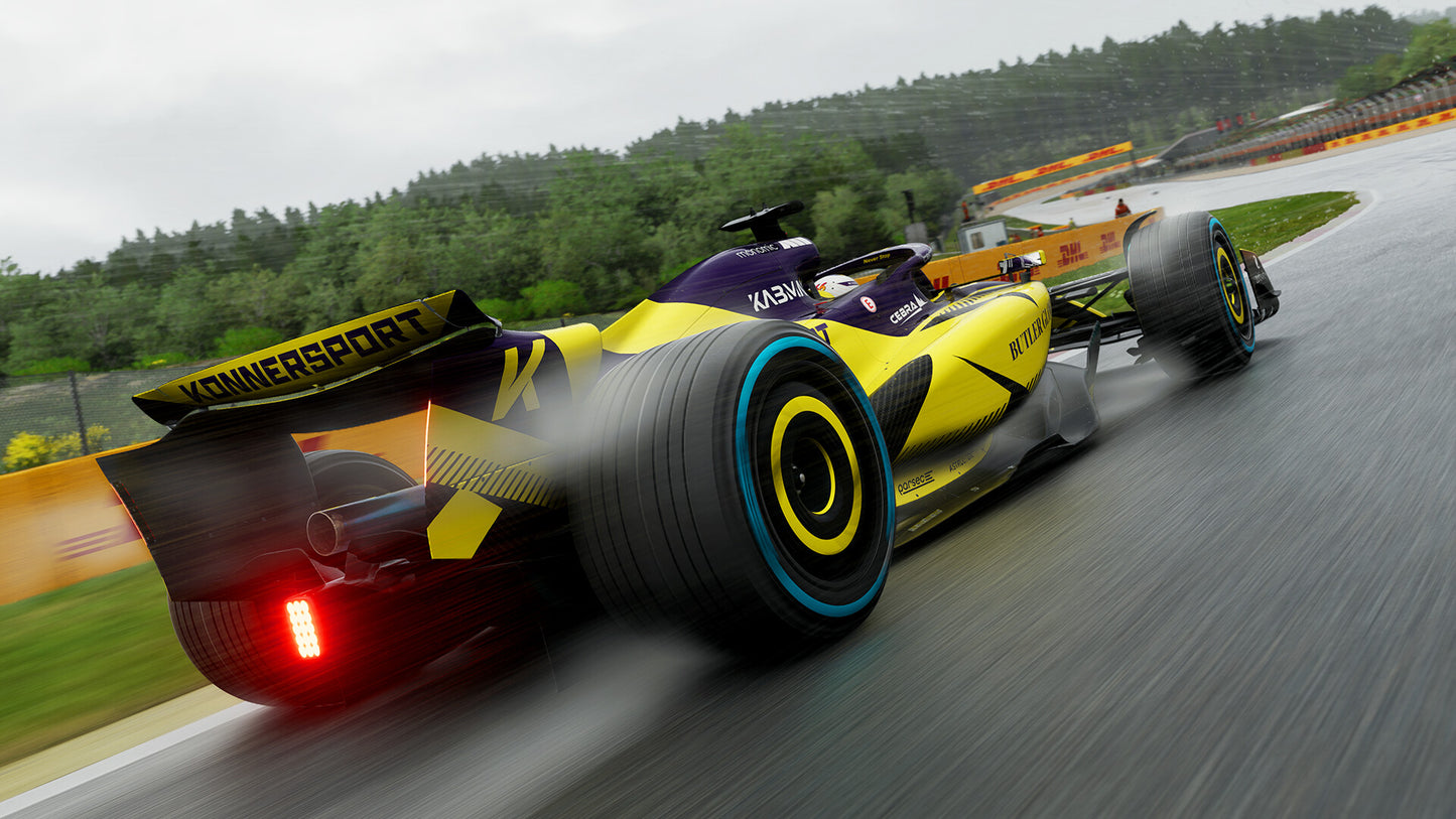 Yellow and black Formula 1 car on a racetrack with trees in the background