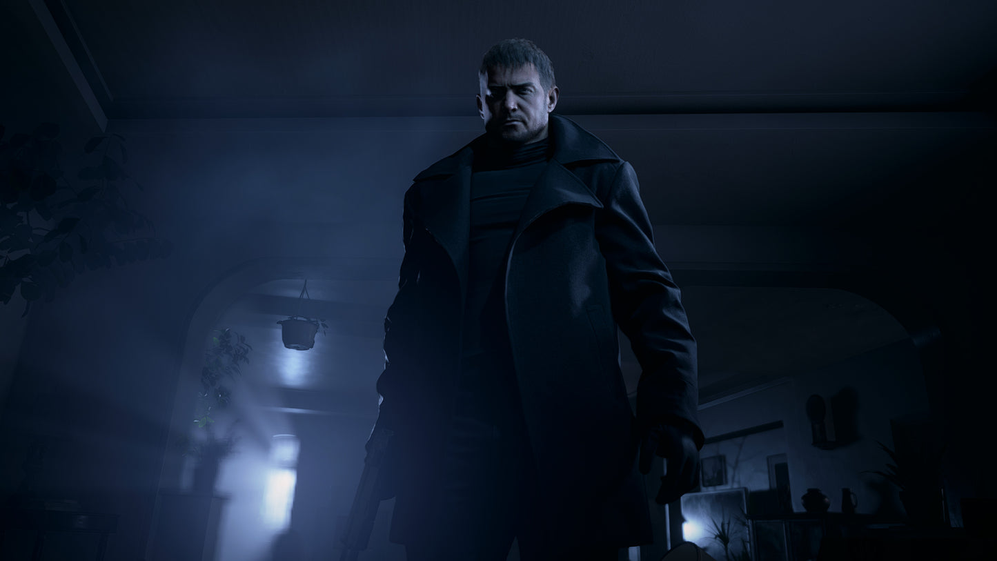 Man in a dark coat standing in a dimly lit room with a blurred background