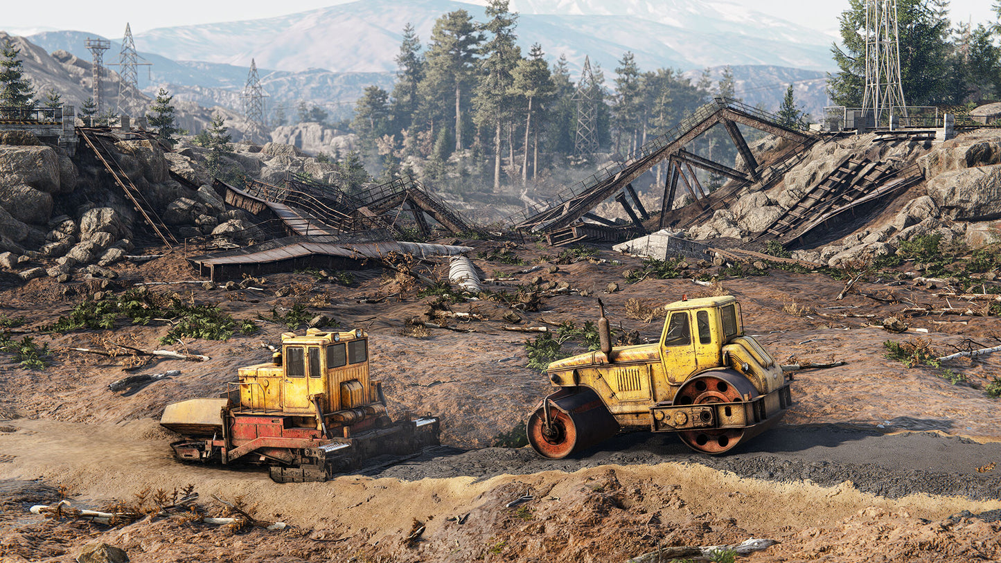 Two yellow construction vehicles on a dirt road with a destroyed bridge and forest in the background.