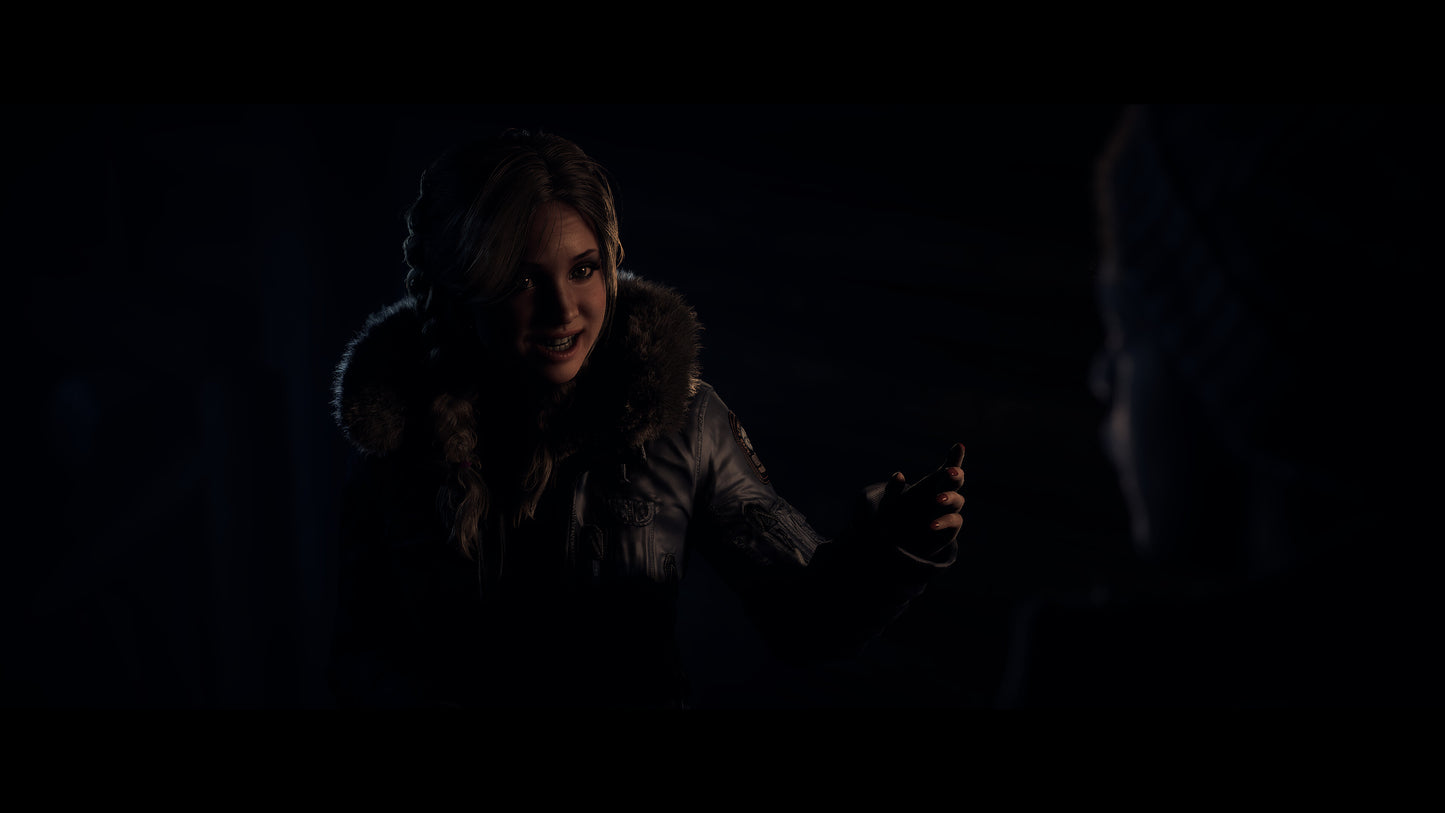 Two people in a dark setting, one holding a small object.