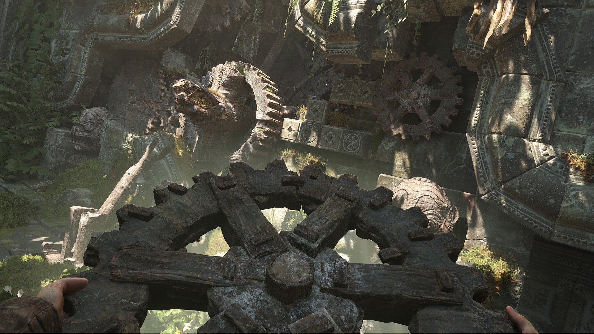 Close-up of large stone gears in a natural setting with greenery.
