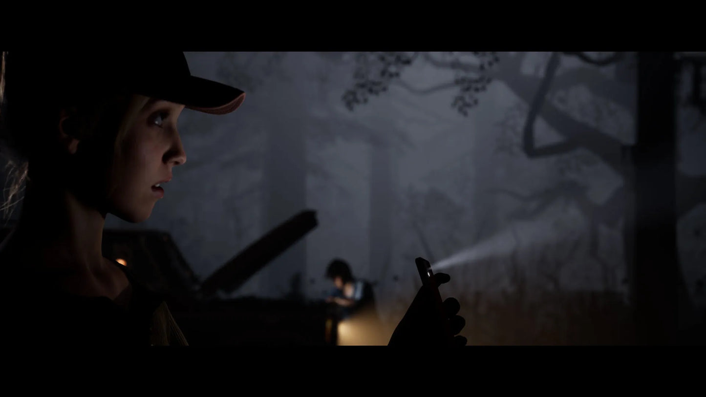 Person holding a flashlight in a dark forest setting
