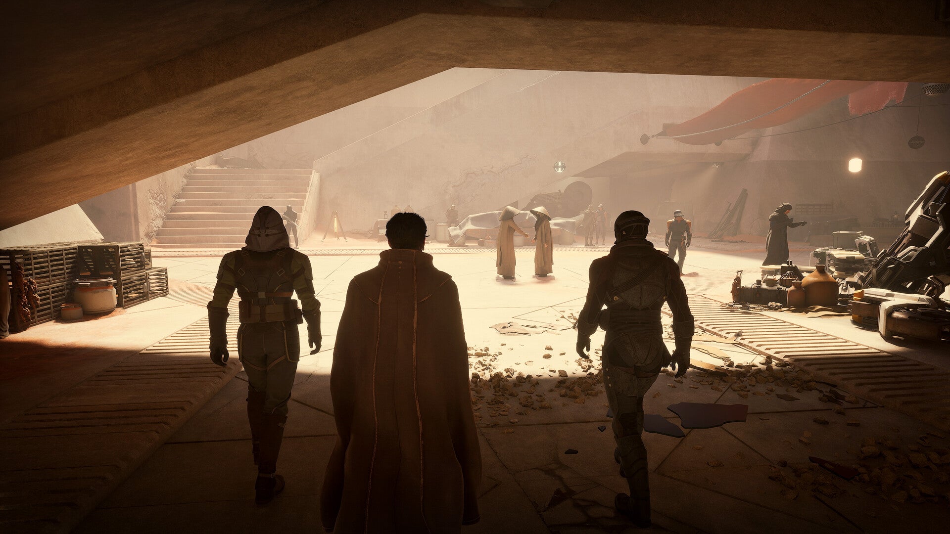 Three characters in futuristic attire walking through a desert-like environment with vehicles and structures in the background.