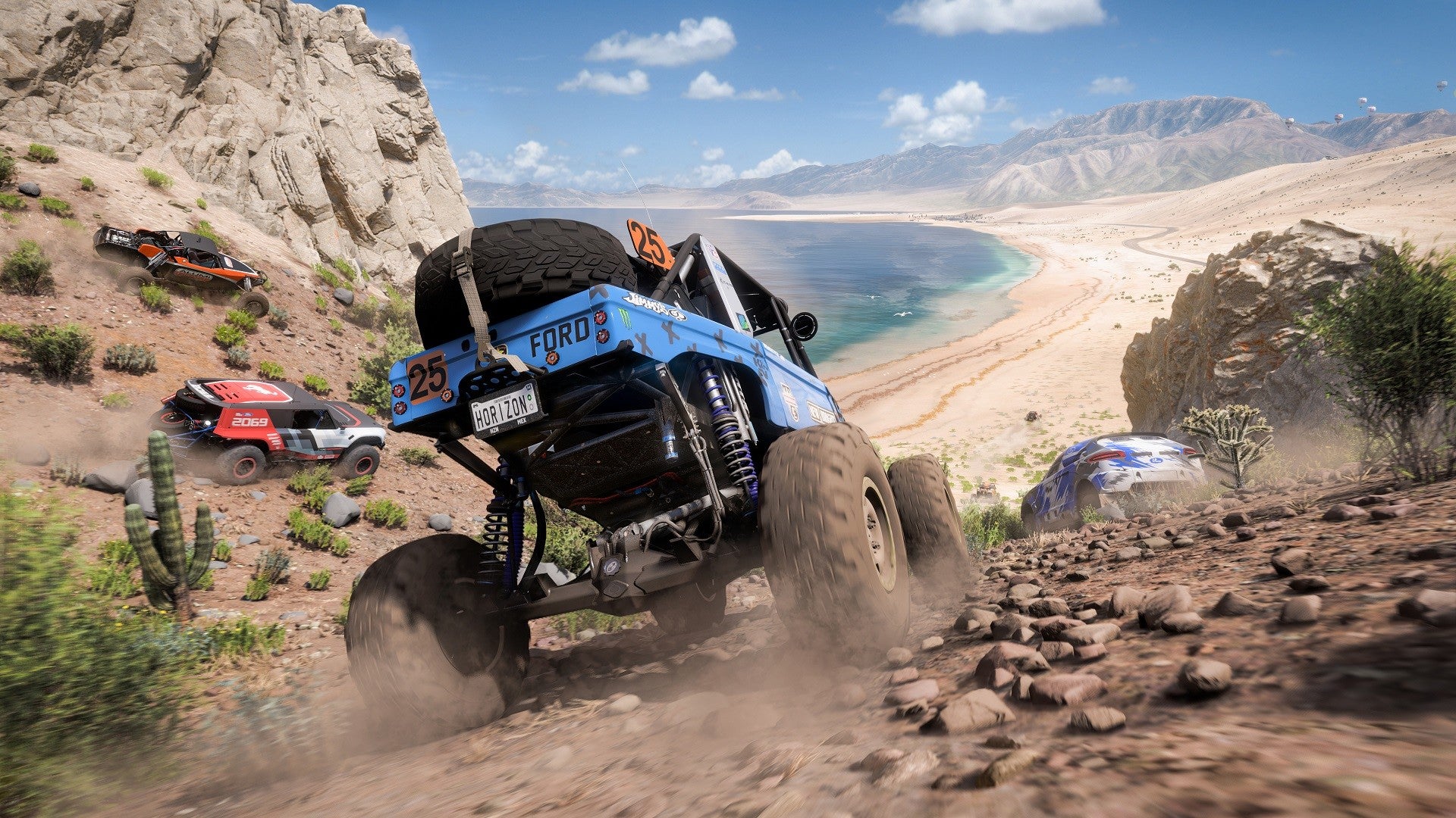 Off-road vehicle on a rocky trail with mountains and water in the background