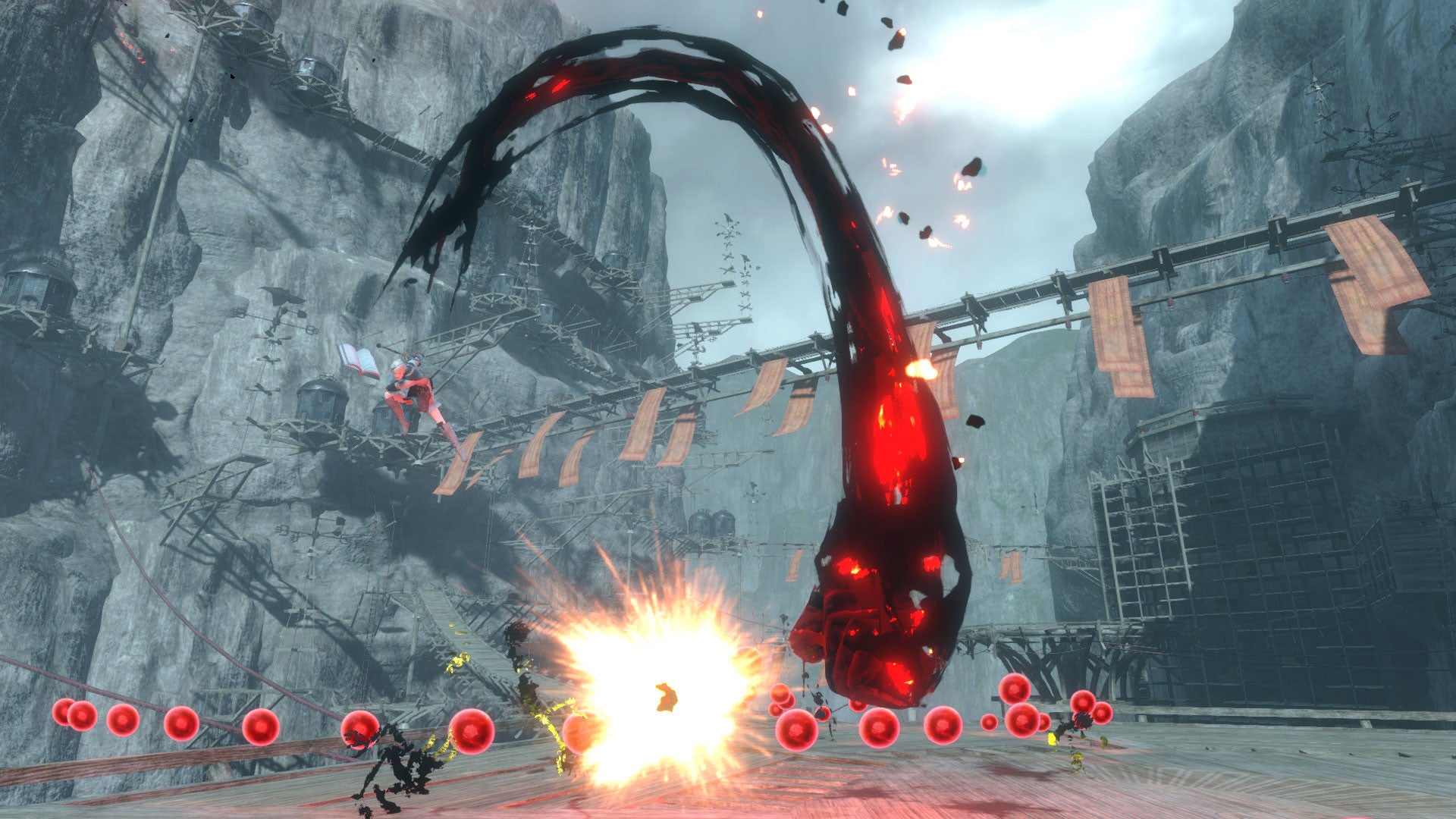 Video game scene with a large mechanical arm and explosions in a rocky environment