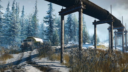 Vintage truck on a snowy road with a large pipeline structure in a forested area