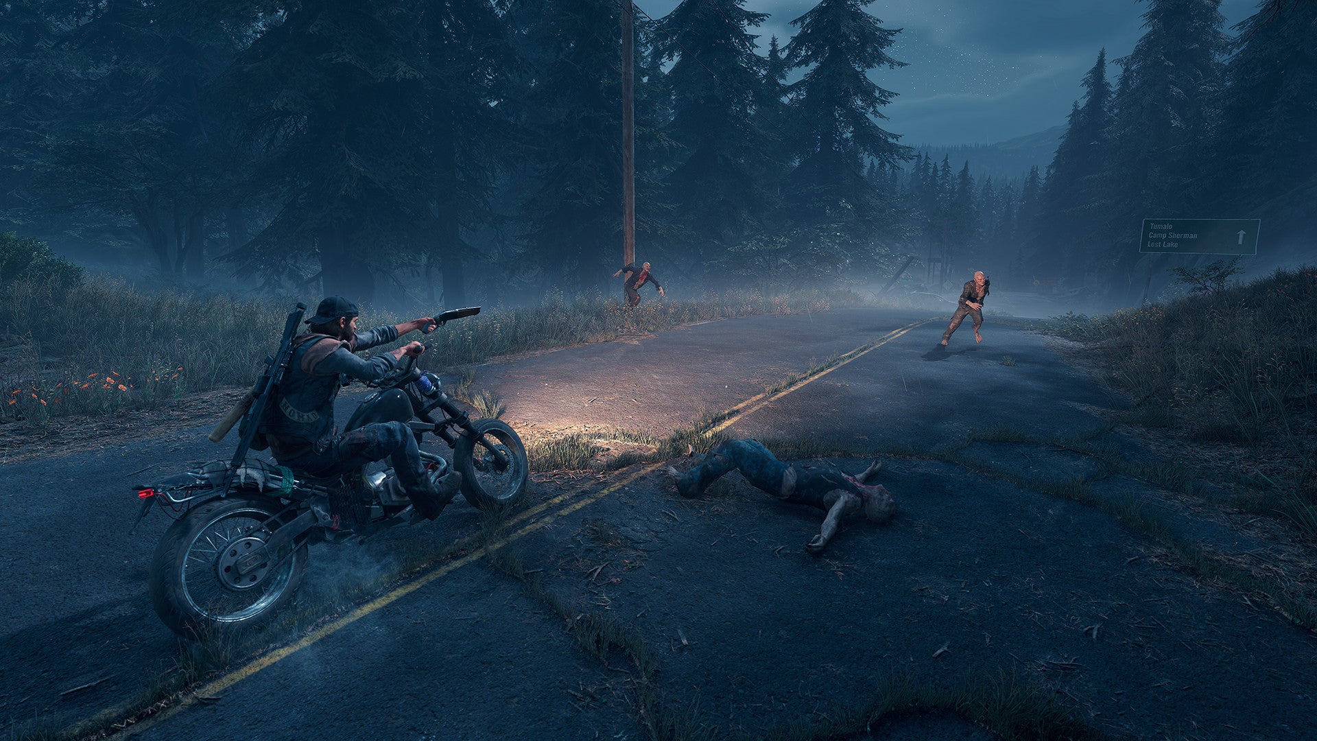 Person on a motorcycle in a forested area with a person lying on the ground and another person in the distance.