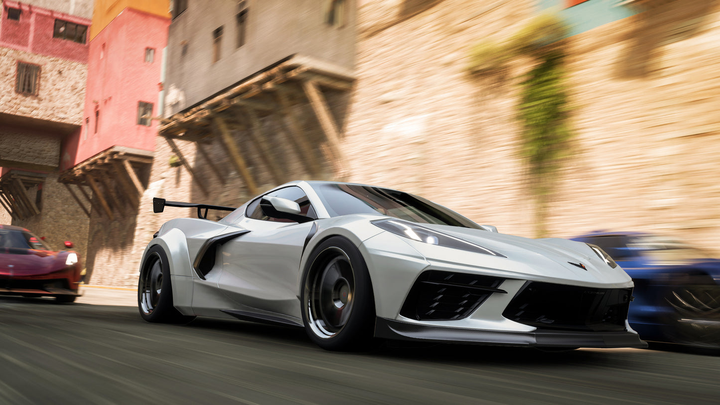 Silver sports car racing on a street with colorful buildings in the background
