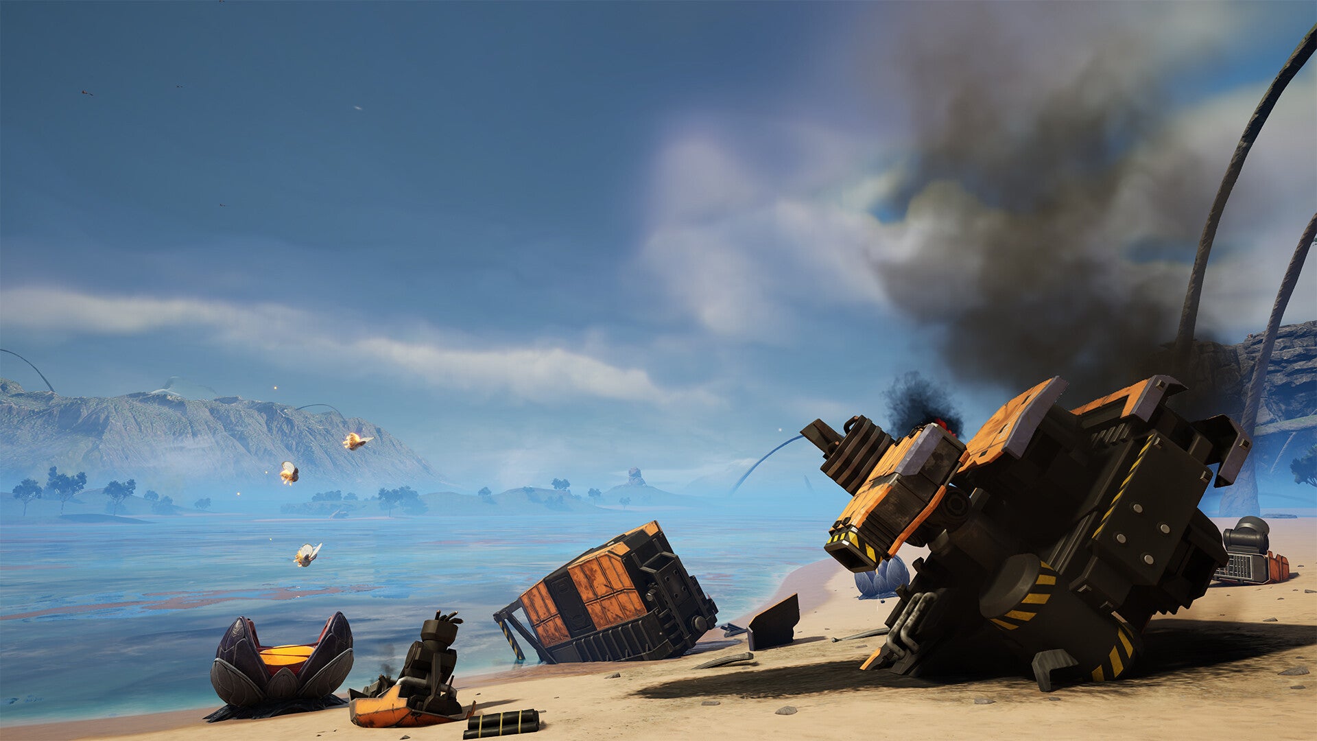 Wrecked vehicles on a beach with mountains and sky in the background