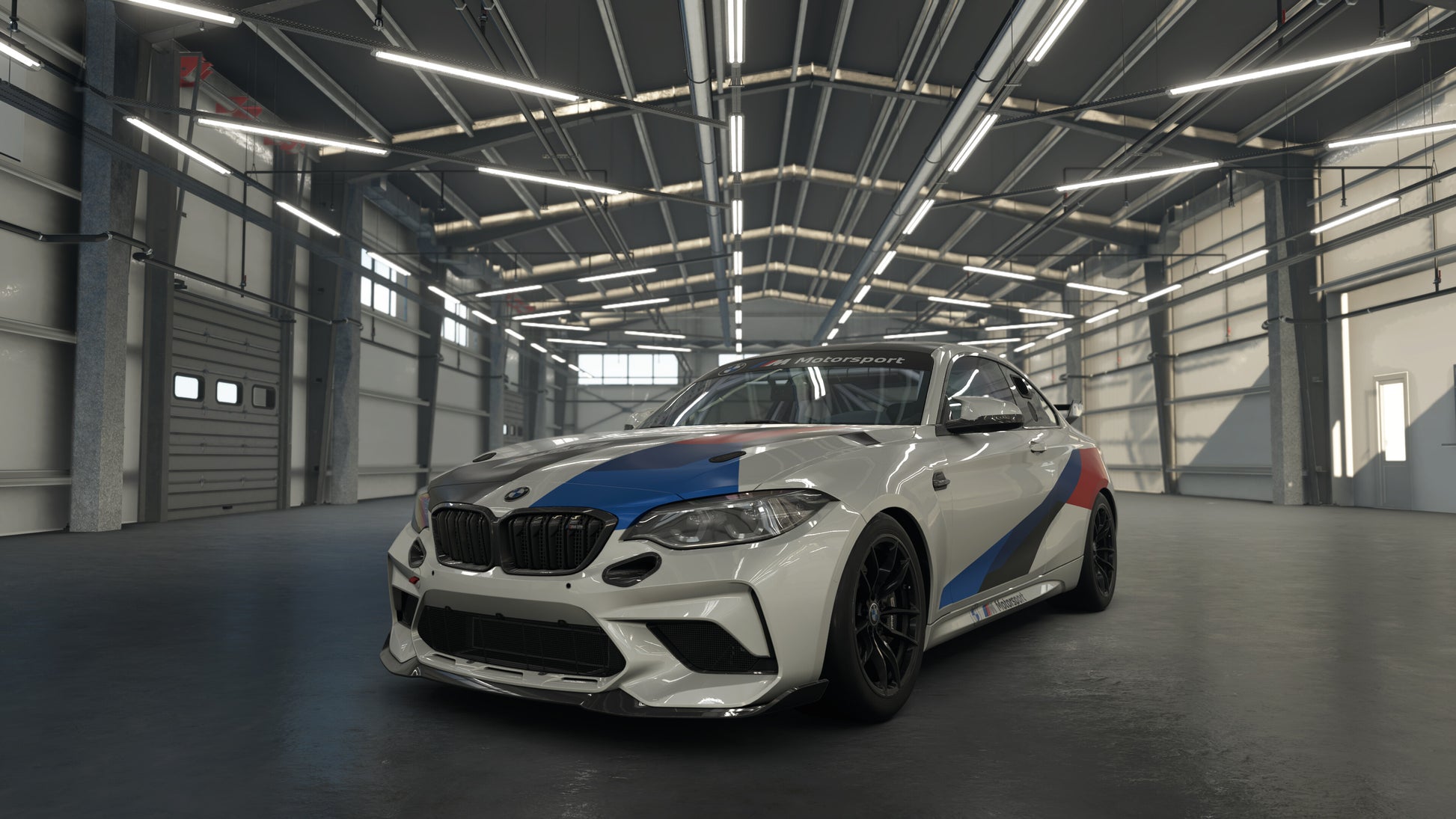 White BMW car with blue and red stripes in a large industrial garage.