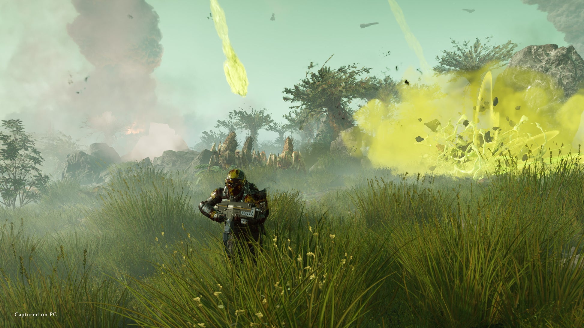 Character in a grassy field with explosions and smoke in the background