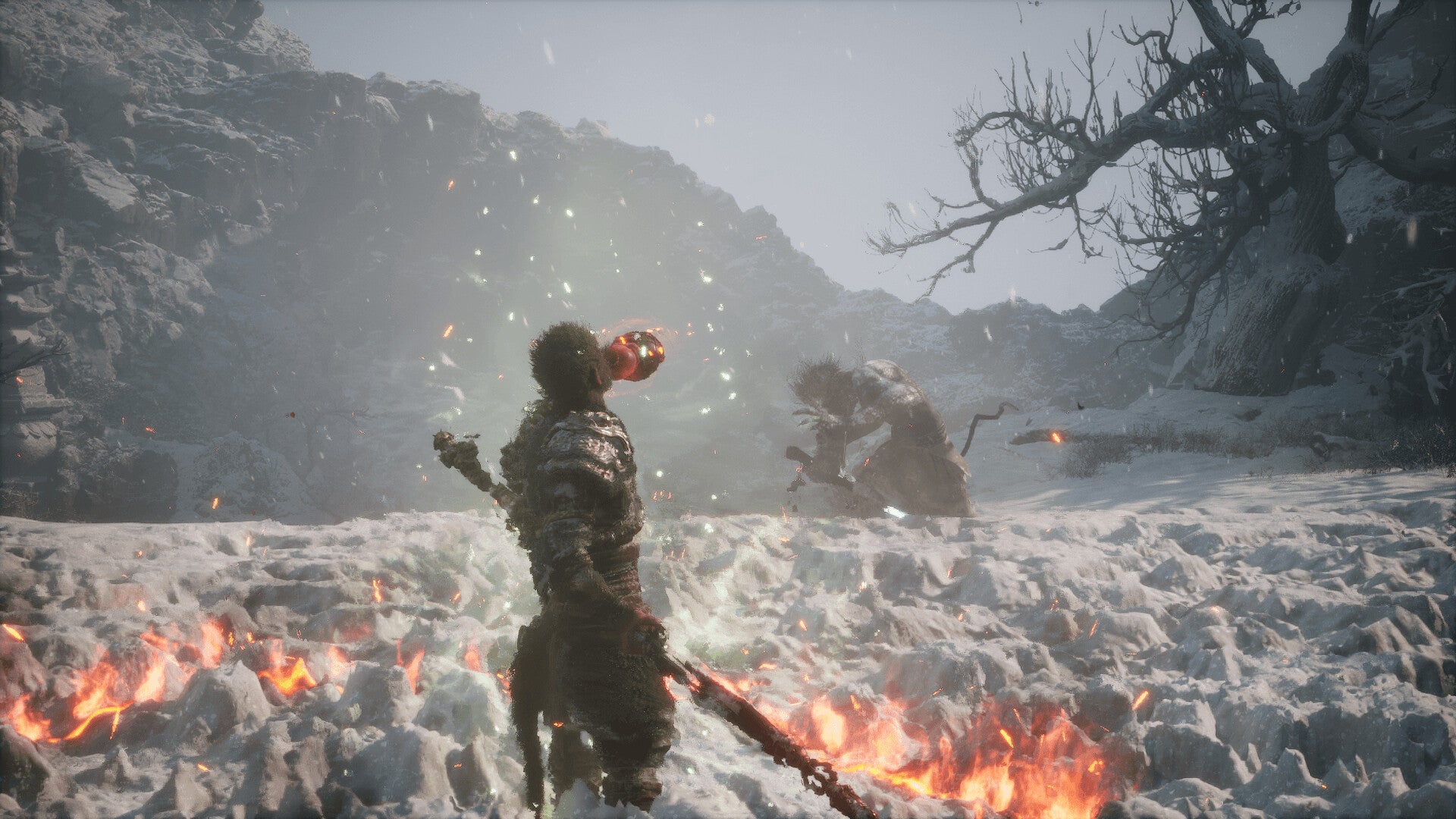 Two characters in a snowy landscape with a fire, surrounded by mountains and bare trees.