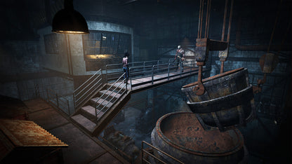 Dark industrial setting with two people on a platform and barrels in the foreground