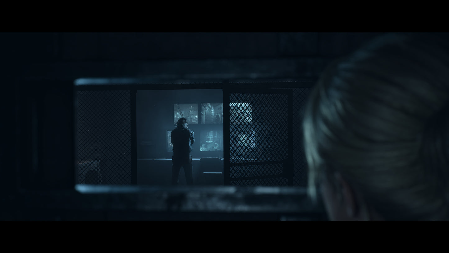 Person observing another person through a grille in a dimly lit room