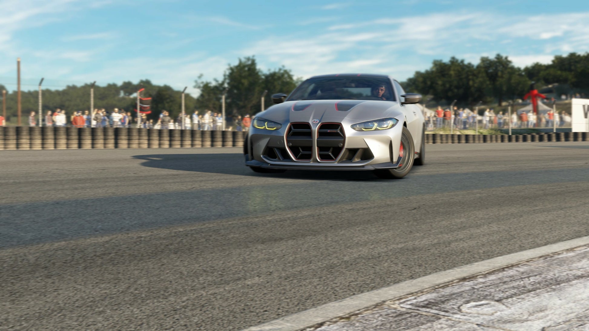Silver sports car on a track with spectators in the background