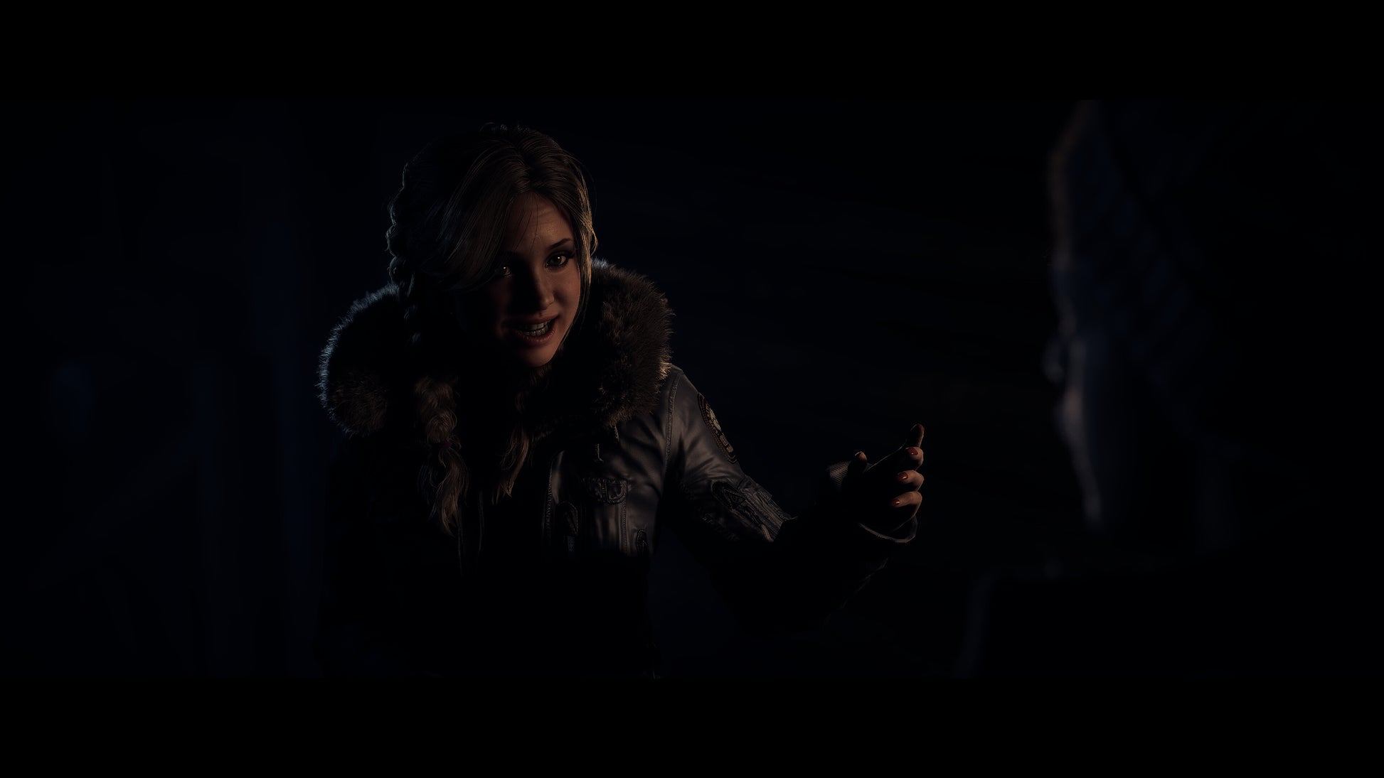 Two people in a dark setting, one holding a small object.