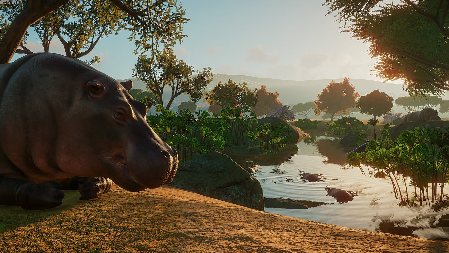 Hippo by a river with trees and mountains in the background