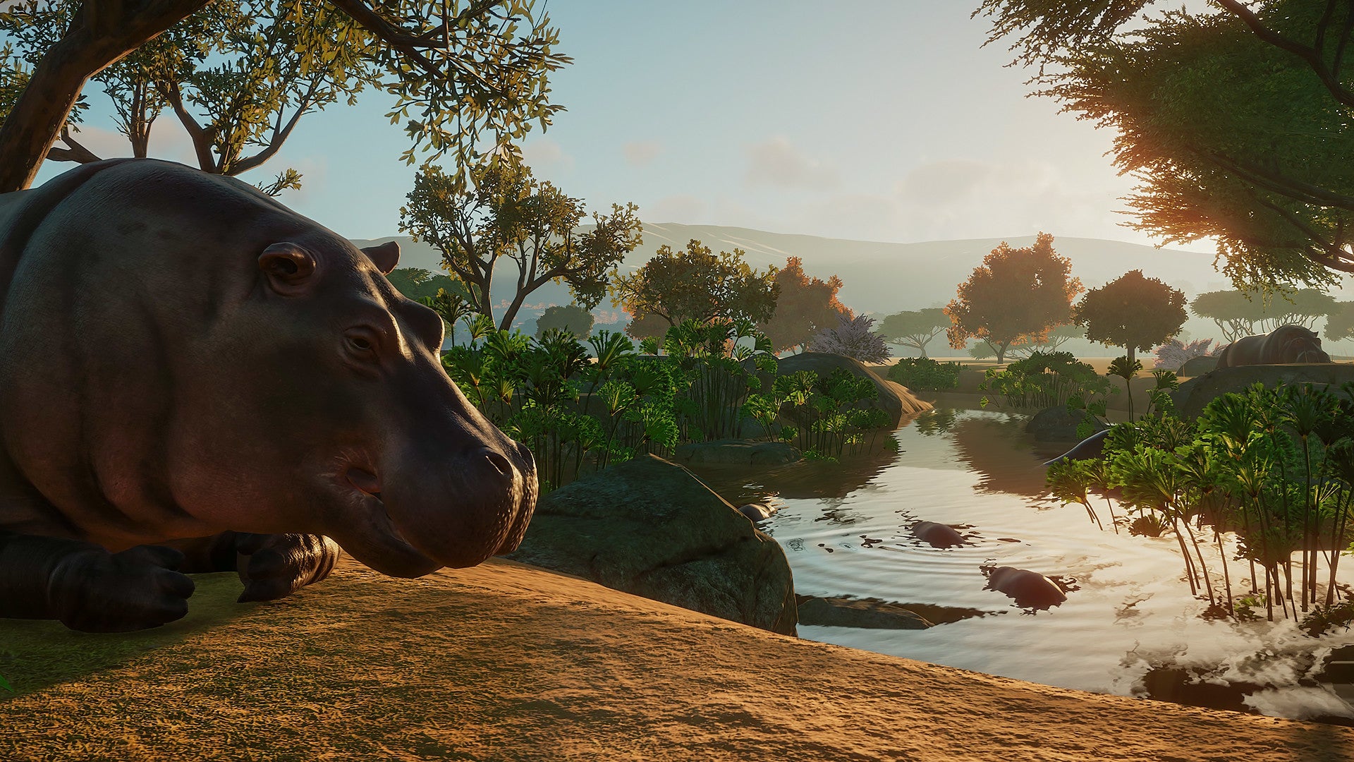 Hippo by a river with trees and mountains in the background