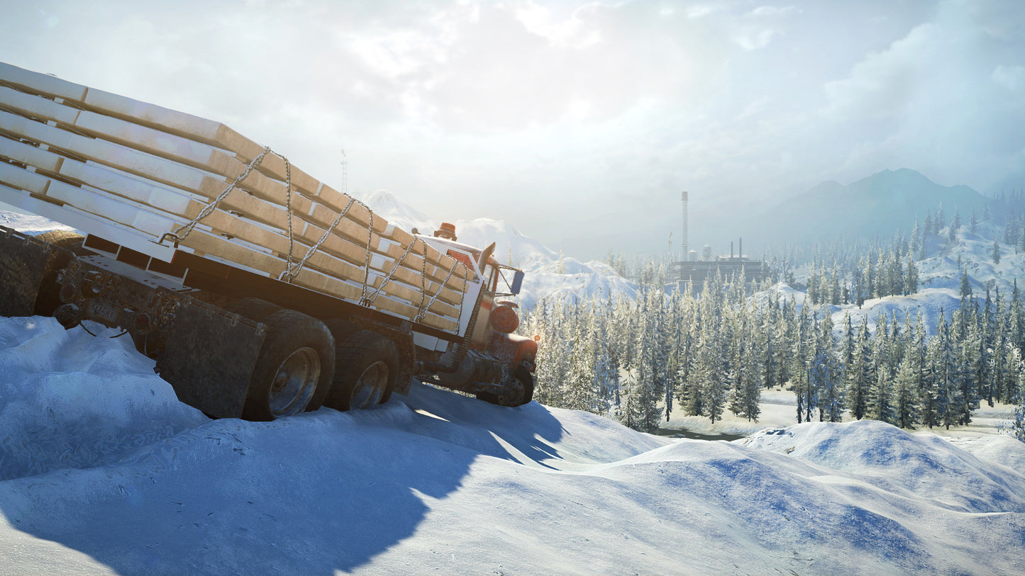 Truck loaded with logs driving on a snowy road with trees and mountains in the background