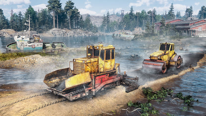 Two yellow bulldozers on a construction site by a body of water with boats and buildings in the background.